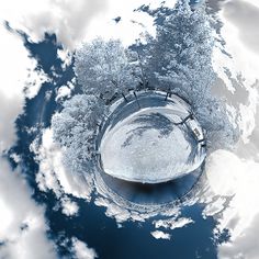 an aerial view of trees and clouds in the sky, taken from above with a fisheye lens