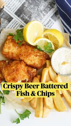 fish and chips on a plate with lemon wedges