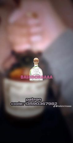 a person holding a bottle in front of their face with the caption, patron