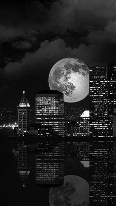 black and white photograph of city skyline with full moon