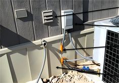 an air conditioner attached to the side of a building with wires and plugs