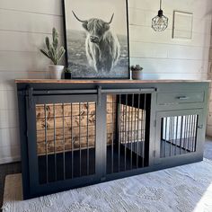 an animal cage is in front of a painting on the wall