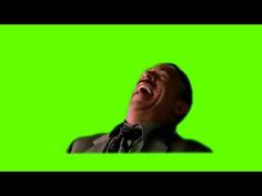 a man laughing while standing in front of a green screen with his mouth wide open