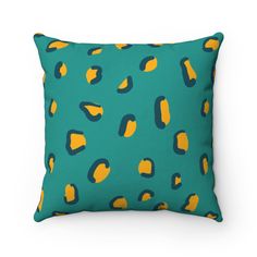 a green pillow with yellow and blue shapes on it