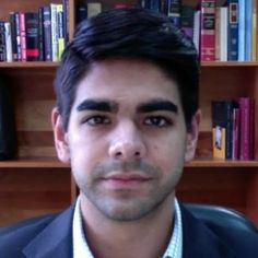 a man is sitting in front of bookshelves