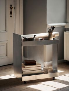 a table that has some books on it in the middle of a room with white walls