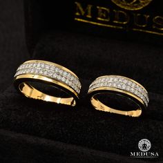 two gold rings with diamonds on them in a black velvet box, next to a medusa logo