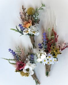 three bouquets of flowers are arranged on the wall