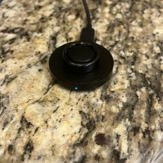 a black device sitting on top of a marble counter