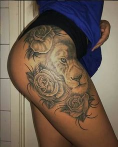 a woman with a lion and roses tattoo on her thigh