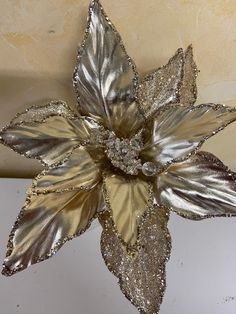 a silver and gold flower is hanging from the ceiling