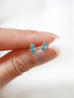 Tiny marquis stud earrings in a vibrant sky blue, also the birthstone for the month of December. Hand set faceted pinched oval cubic zirconia subtly catch the light.  Hardware has been tumble polished for hours to achieve a satin finish, butterfly backings.  Packaged in a beautiful gift box.Perfect for standard lobe piercings and make great stacking pieces for 2nd and 3rd piercings (shown worn in the last photo, paired with our micro star studs https://www.etsy.com/listing/706430537/  ).MATERIAL Dainty Marquise Earrings As Gift, Dainty Marquise-cut Jewelry As A Gift, Dainty Marquise Cut Jewelry For Gifts, Marquise Cut Birthstone Jewelry Gift, Dainty Marquise Cut Jewelry As Gift, Gift Sterling Silver Marquise Cut Earrings, Blue Marquise Cut Jewelry For Gift, 3rd Piercings, Lobe Piercings