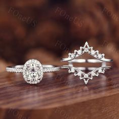 three different types of wedding rings sitting on top of a wooden table