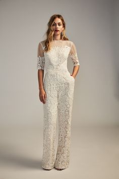 a woman in white lace jumpsuits posing for the camera with her hands on her hips