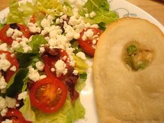 a salad with tomatoes, lettuce and feta cheese is on a plate