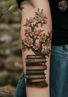 a person with a tattoo on their arm that has books and a tree growing out of it