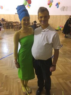 a man and woman standing next to each other in a room with balloons on the ceiling