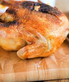 a chicken sitting on top of a wooden cutting board