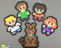 four pixelated video game characters are arranged in the shape of magnets on a gray surface