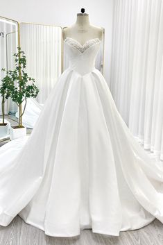 a white wedding dress on display in front of a mirror