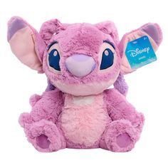 a pink stuffed animal with blue eyes and ears sitting on a white surface next to a tag that says disney