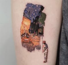 a person with a tattoo on their arm that has an image of a man standing in front of a city at night