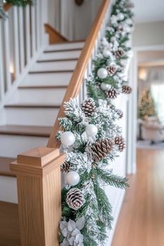 christmas garland with pine cones and white balls on the banister