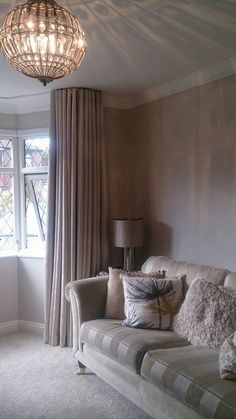 a living room filled with furniture and a chandelier hanging over the top of it