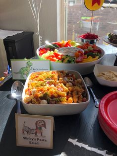 a table topped with lots of different types of food next to plates and spoons