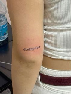 a woman with a tattoo on her arm that says, godspeeded in cursive writing