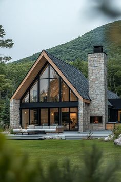 a house with a stone chimney and large windows