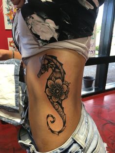 a woman's stomach with a tattoo on her lower body and the word seahorse