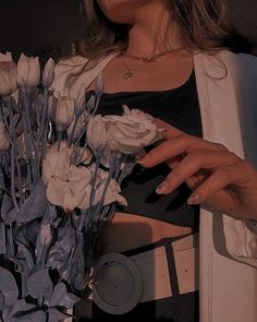 a woman holding a bouquet of white roses