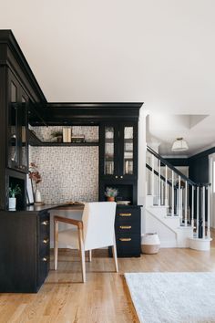 a dining room table and chairs in front of a black cabinet with glass doors on it