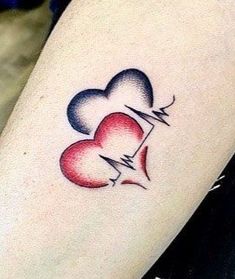 two hearts with an arrow tattoo on the arm