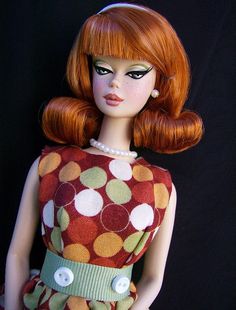 a doll with red hair wearing a polka dot dress