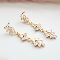 Art Deco inspired, geometric and dangly, these earrings will take you back to the 1920s era. It features 3 tiered leaf shaped glass crystals finished with a vermeil (gold plated sterling silver) push back/stud closure.Due to hygienic reasons, I do not accept exchanges/returns on earringsMaterials : glass crystal with gold plated bezel, vermeil ear stick.DIMENSION:----------------Earrings : 6 mm wide x 40 mm long (0.23 inch x 1.6 inch) Art Deco Gold Dangle Bridal Earrings, Gold Art Deco Dangle Bridal Earrings, Gold Art Deco Drop Bridal Earrings, Art Deco Gold Drop Bridal Earrings, Gold Art Deco Bridal Earrings For Gift, Gold Art Deco Bridal Earrings Gift, Art Deco Gold Jewelry With Cubic Zirconia, Art Deco Gold Cubic Zirconia Jewelry, Gold Art Deco Bridal Earrings