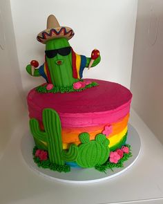 a colorful cake with a cactus on top