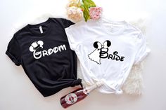 two t - shirts with diamond rings on them sitting next to each other, one is black and the other is white