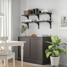 a dining room table and chairs with shelves on the wall