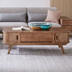 a coffee table with a bowl on it in front of a couch