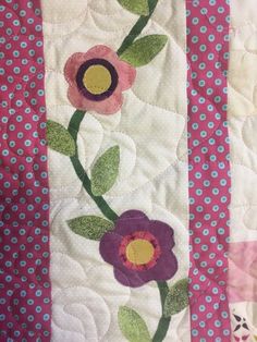 a close up of a quilt with flowers on it