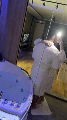 a man taking a selfie in front of a bathroom mirror with a jacuzzi tub