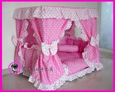 a pink bed with white polka dots on the top and bottom, has a canopy over it