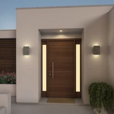 a modern entrance with two planters and lights