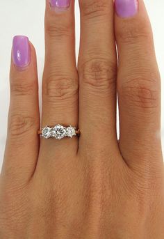 a woman's hand with purple manicured nails and a ring on her finger