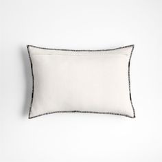 a white and black pillow on a white wall with a black border around the edges