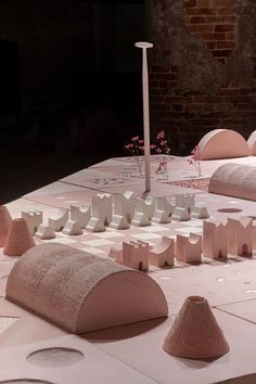 several pieces of art sit on top of a white table with pink and white tiles