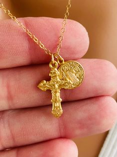 "This is a small gold Italian style Crucifix Cross along side a small Saint Benedict medallion.  Both charms are made of matte gold over 925 sterling. These little charms come on a shiny, 14kt yellow gold filled cable chain. These gorgeous charms are made by master silversmiths here in the USA.  Such attention to detail these pendants are so exquisite that the photos do not do them justice!  This dainty crucifix  cross measures 22x14mm, Saint Benedict medal measures 11mm.   Comes in a gift box ready to present. Model is wearing the gold 16\" length. This necklace is also available in 925 sterling silver." Catholic Jewelry Necklace, Saint Benedict Medal, St Benedict Cross, Edgars Haircut, Benedict Medal, Sterling Silver Cross Necklace, St Benedict, Saint Benedict, Catholic Jewelry