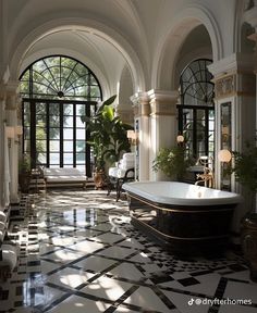 an ornate bathroom with black and white tile flooring, arched windows, and large bathtub